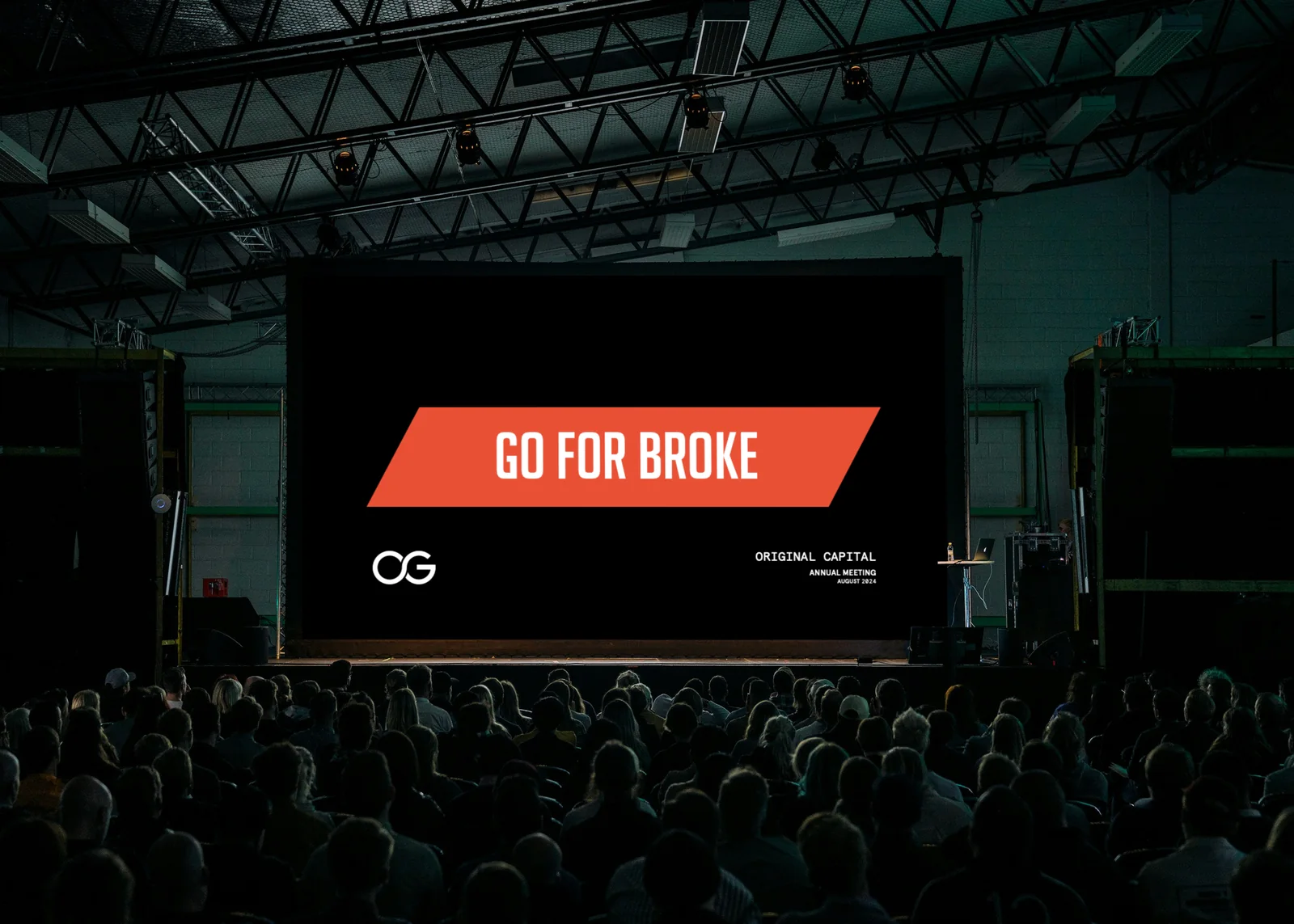 Original Capital presentation slide, Go for broke, on a large stage screen in front of an audience